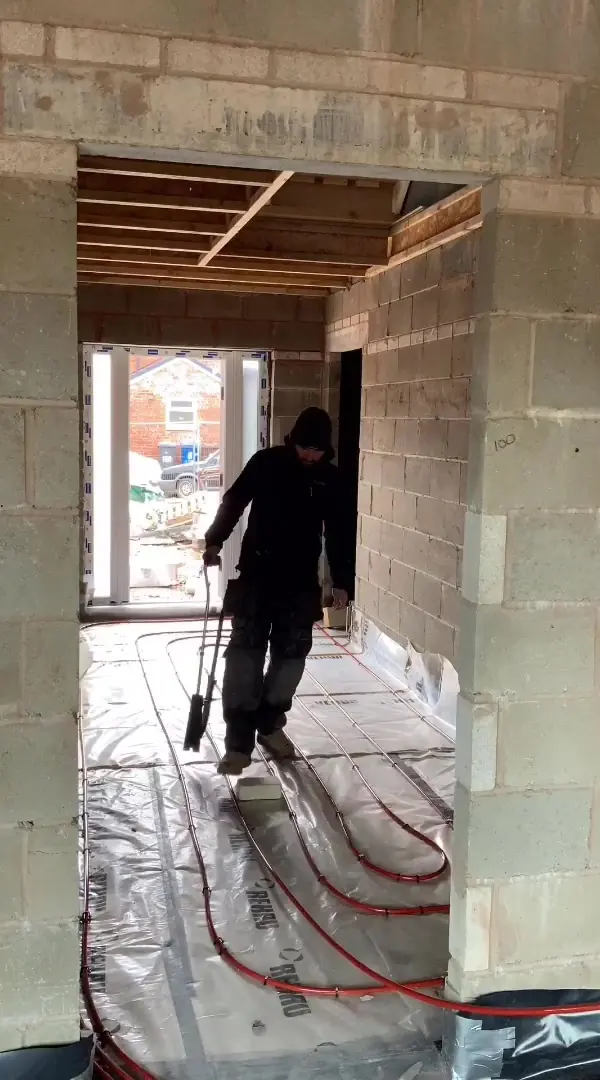Callum laying underfloor heating pipework